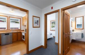 a kitchen with white walls and wooden doors at City Apartment South Street in Nelson