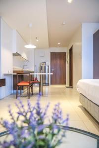 a room with a bed and a table and a kitchen at Top Floor Studio Non-Resort Unit Tambuli Tower D in Maribago