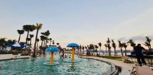 a swimming pool at a resort with palm trees at V3L05-Sonasea Vân Đồn in Thâm Câu
