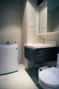 a bathroom with a sink and a toilet and a mirror at Top Floor Studio Non-Resort Unit Tambuli Tower D in Maribago +9 photos