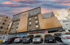 a group of cars parked in a parking lot in front of a building at Masan First Class Hotel in Changwon