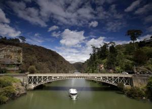a boat in a river under a bridge at The Old Federal Coffee Palace in Launceston