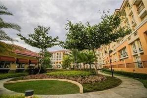 a walkway in a courtyard with trees and buildings at Sanremo Oasis Staycation in Cebu City