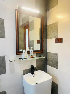a bathroom with a white sink and a mirror at Cinnamon Crown in Matara +67 photos