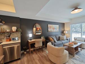 a living room with a couch and a table at New Luxury MountainView Downtown2B2B RooftopHottub in Canmore