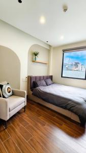 a bedroom with a bed and a couch and a window at 4Chan Phúc Đồng Apartment in Hanoi