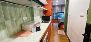 a kitchen with orange and green walls and a counter top at 4Chan Phúc Đồng Apartment in Hanoi +9 photos