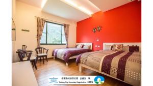 two beds in a room with red walls at 春夏秋冬民宿 - 臺東縣民宿1095號 in Guanshan