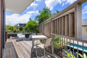 a deck with a table and chairs next to a pool at Grottamare in Lennox Head