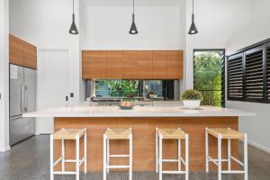 a kitchen with a large island with four bar stools at Grottamare in Lennox Head