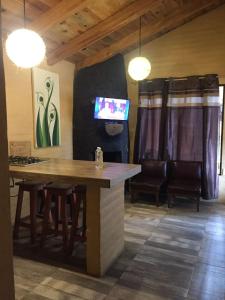 a dining room with a table and chairs and a tv at Cabañas Quinta de Cuevas in Mazamitla