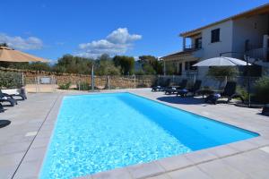 - une piscine en face d'une maison dans l'établissement Les Terrasses Du Grand Large, à Porto Pollo