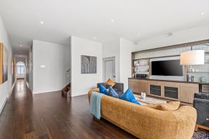 a living room with a couch and a tv at Complete Host Middle Park House in Melbourne