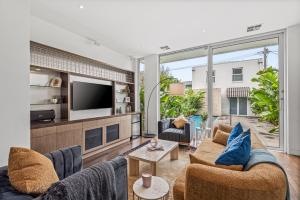 a living room with two couches and a tv at Complete Host Middle Park House in Melbourne