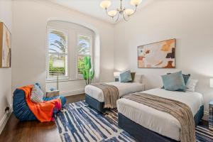 a bedroom with two beds and a chair in it at Complete Host Middle Park House in Melbourne +26 photos