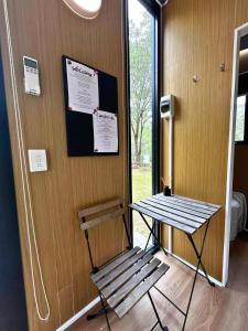 a bench and a table in a room with a window at Mirror Reflections 2 by Tiny Away in Tamborine