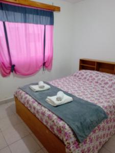 a bedroom with a bed with two towels on it at Gemelas Andinas in Trevelín