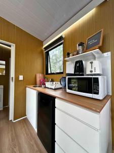a kitchen with a counter top with a microwave at Mirror Reflections 2 by Tiny Away in Tamborine