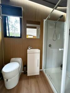 a small bathroom with a toilet and a shower at Mirror Reflections 2 by Tiny Away in Tamborine