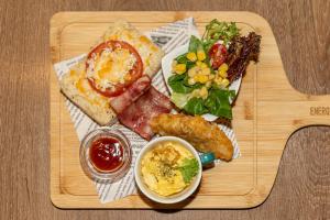 a wooden tray with a plate of food with meat and a salad at Energy Inn in Taipei
