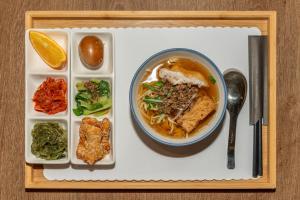 a tray with a bowl of soup and a plate of food at Energy Inn in Taipei