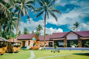 a house with palm trees in front of it at H&P Beach Resort in Pandan +4 photos