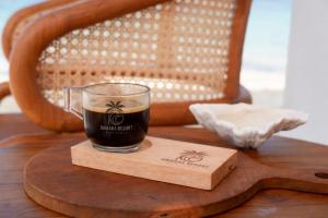 a glass of coffee sitting on a wooden table at Ombara Resort Mentawai in Katiet +33 photos