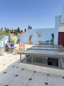 a picnic table on a patio with chairs and tables at Riad Nomad House Marrakech in Marrakesh