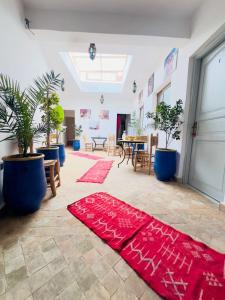 a room with plants and red carpets on the floor at Riad Nomad House Marrakech in Marrakesh