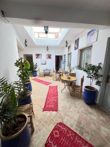 a large room with plants and a table and chairs at Riad Nomad House Marrakech in Marrakesh