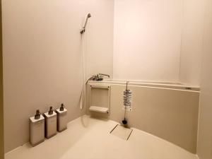 a white bathroom with three trash cans in it at ura Auberge Craft in Hokancho +27 photos