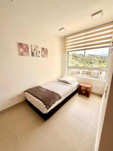 a bedroom with a bed and a large window at Apartamento en Villeta in Villeta +6 photos