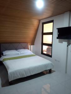 a bedroom with a bed with a window and a television at H&P Beach Resort in Pandan