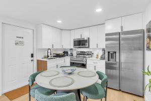 a kitchen with white cabinets and a table and chairs at The Oasis Signature in Miami