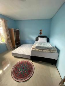 a bedroom with a bed and a rug on the floor at Wel home stay in Pulau Gilimota
