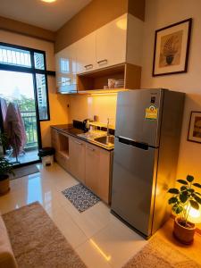 a kitchen with a stainless steel refrigerator and a sink at treasure swimming condo in Chiang Mai