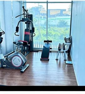 a gym with exercise equipment and a large window at treasure swimming condo in Chiang Mai
