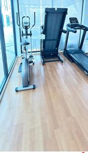 a gym with two exercise bikes and a treadmill at Treasure Condo Kitchenette Wifi in Chiang Mai