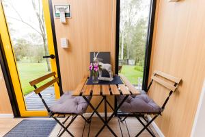 a table with two chairs and a vase of flowers on it at Tranquility Ranch by Tiny Away in Wolfdene