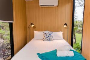 a bedroom with a bed with a towel on it at Tranquility Ranch by Tiny Away in Wolfdene