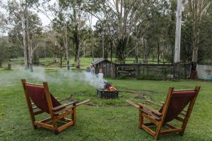 two people standing around a fire in a yard at Tranquility Ranch by Tiny Away in Wolfdene