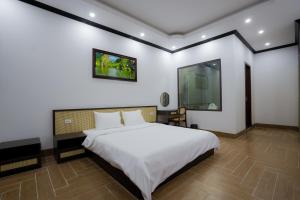 a bedroom with a large white bed in a room at Đậu Homestay Phố Cổ in Ninh Binh