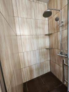 a shower in a bathroom with a wooden wall at Casa Arena & Sol in Santa Rosa +11 photos