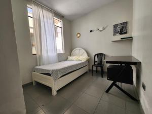 a small bedroom with a bed and a desk at Casa Arena & Sol in Santa Rosa
