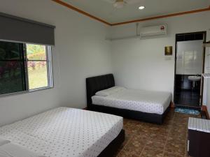 a room with two beds and a window at ACF Guest House in Sungai Lembing
