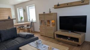 a living room with a couch and a flat screen tv at Ankerplatz35 in Wittmund