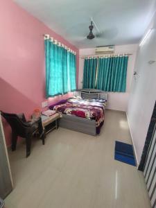 a bedroom with a bed and a desk in a room at Relax inn in Matheran