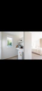 a white room with a bed and a window at Retreat to Pisa in Mount Pisa