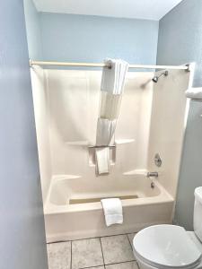 a bathroom with a tub and a toilet and towels at Owensville Inn in Owensville