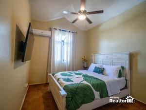 a bedroom with a bed with a ceiling fan at Casa Estrella, Relaxation Begins in Sosúa +25 photos